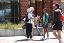 A group of students talking on campus. 