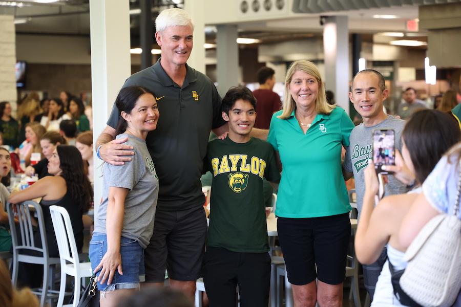 President Livingstone and Brad Livingstone standing with an incoming student and his parents.