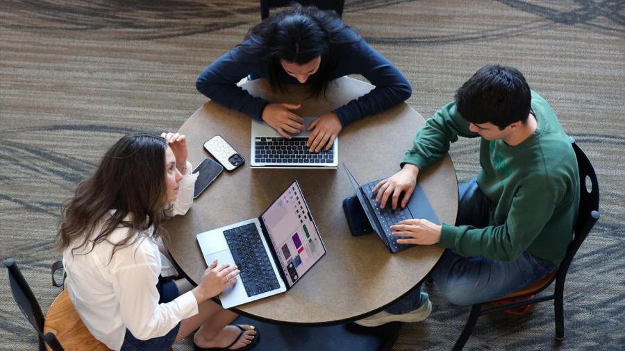 Students gather around a table to study for finals